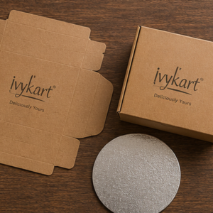 Flat and assembled Ivykart kraft cake boxes with a silver cake board